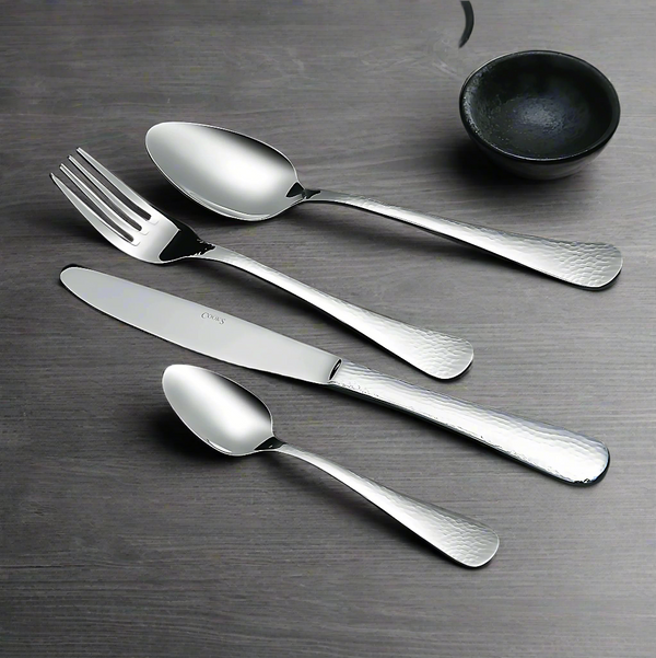 Meran Hammer cutlery set with textured stainless steel finish

Close up of Meran Hammer table knife and fork

Dessert spoon and fork Meran Hammer pattern

Tea spoon and mocca spoon with hammered texture

Table spoon and dessert knife from Meran Hammer collection

Polished stainless steel cutlery with hammered handle design

Meran Hammer flatware displayed on rustic table setting

Elegant hammered stainless steel utensils Meran Hammer